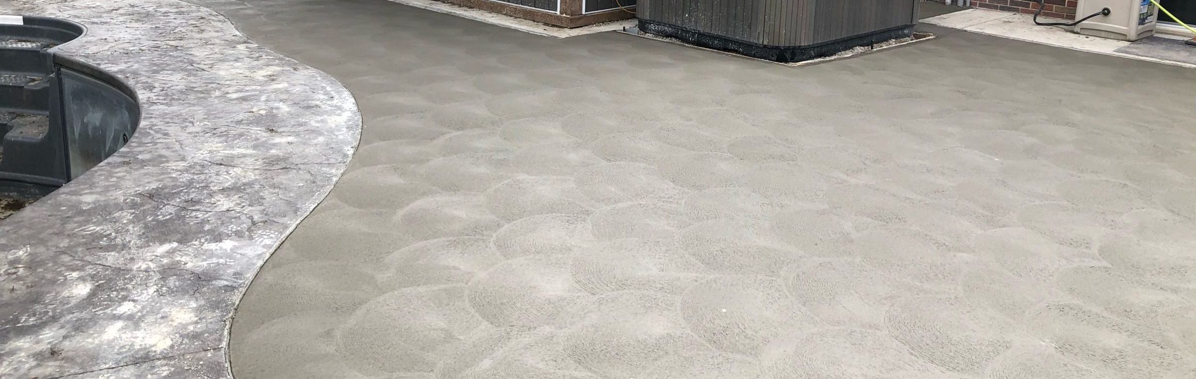 Wide view of a swirl-finished concrete pool deck
