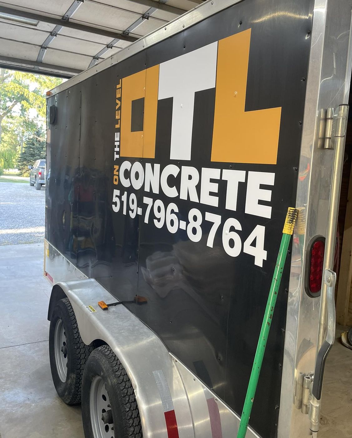 OTL Concrete wrapped trailer with logo and phone number