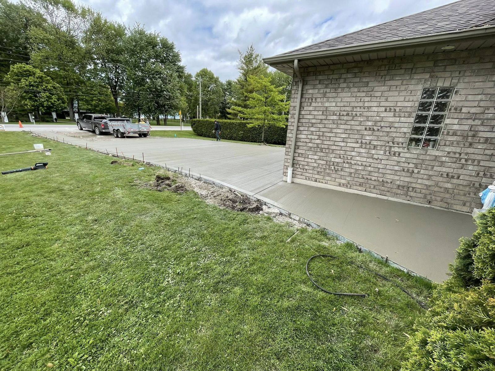 Freshly poured driveway and apron at a brick house