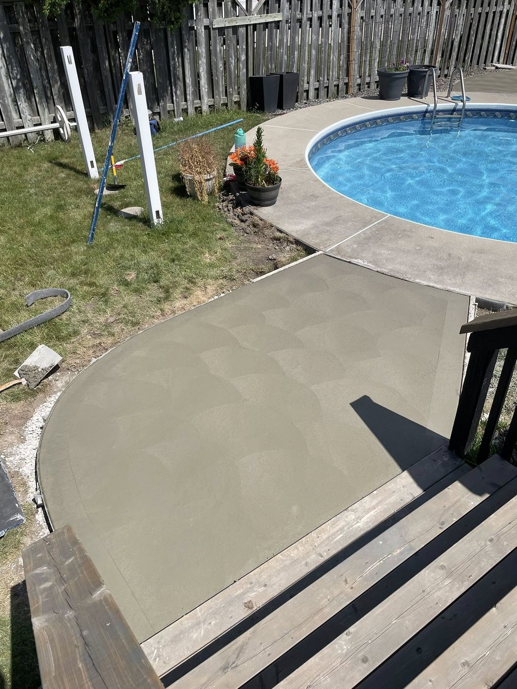 Concrete walkway leading to a pool patio