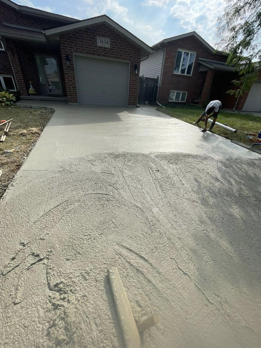 Finisher working fresh concrete on a new driveway
