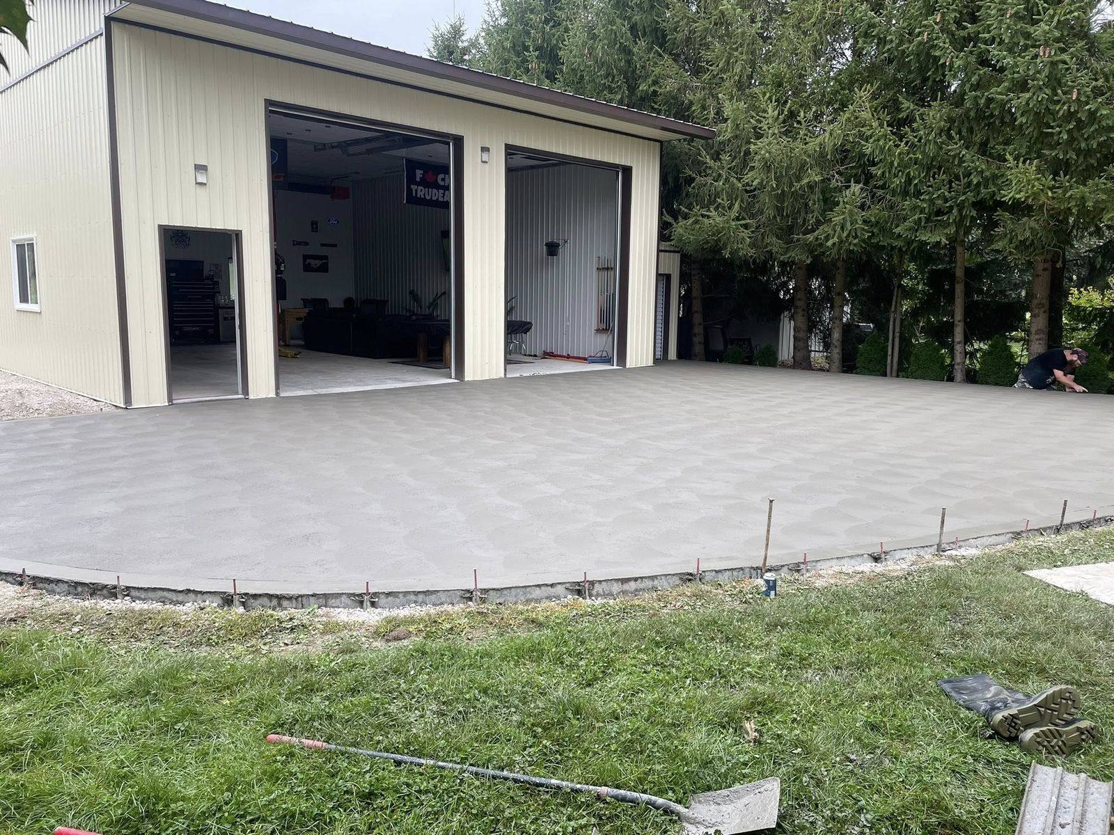 Large freshly poured concrete apron in front of a commercial shop