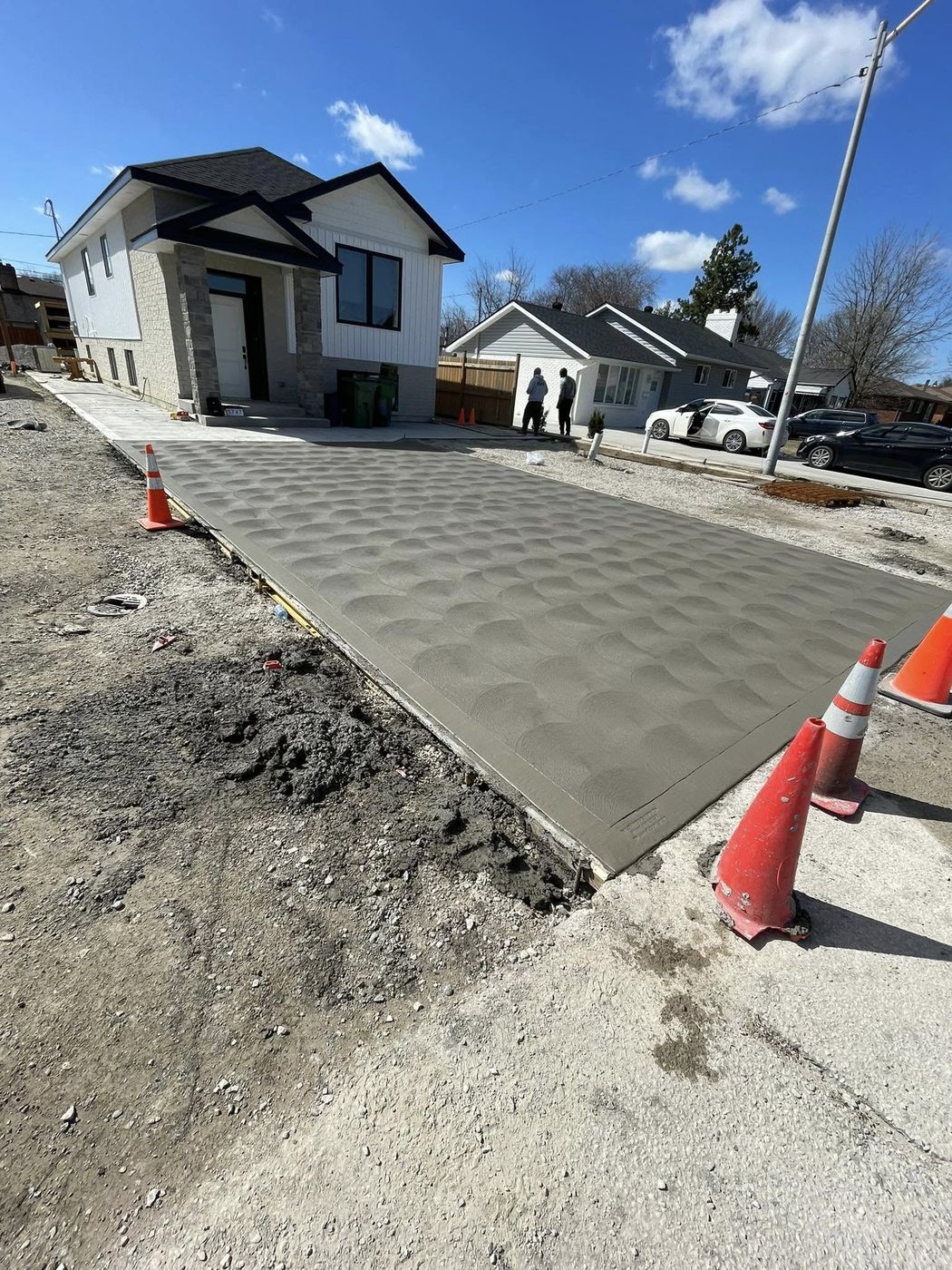 Freshly finished broom-textured concrete driveway