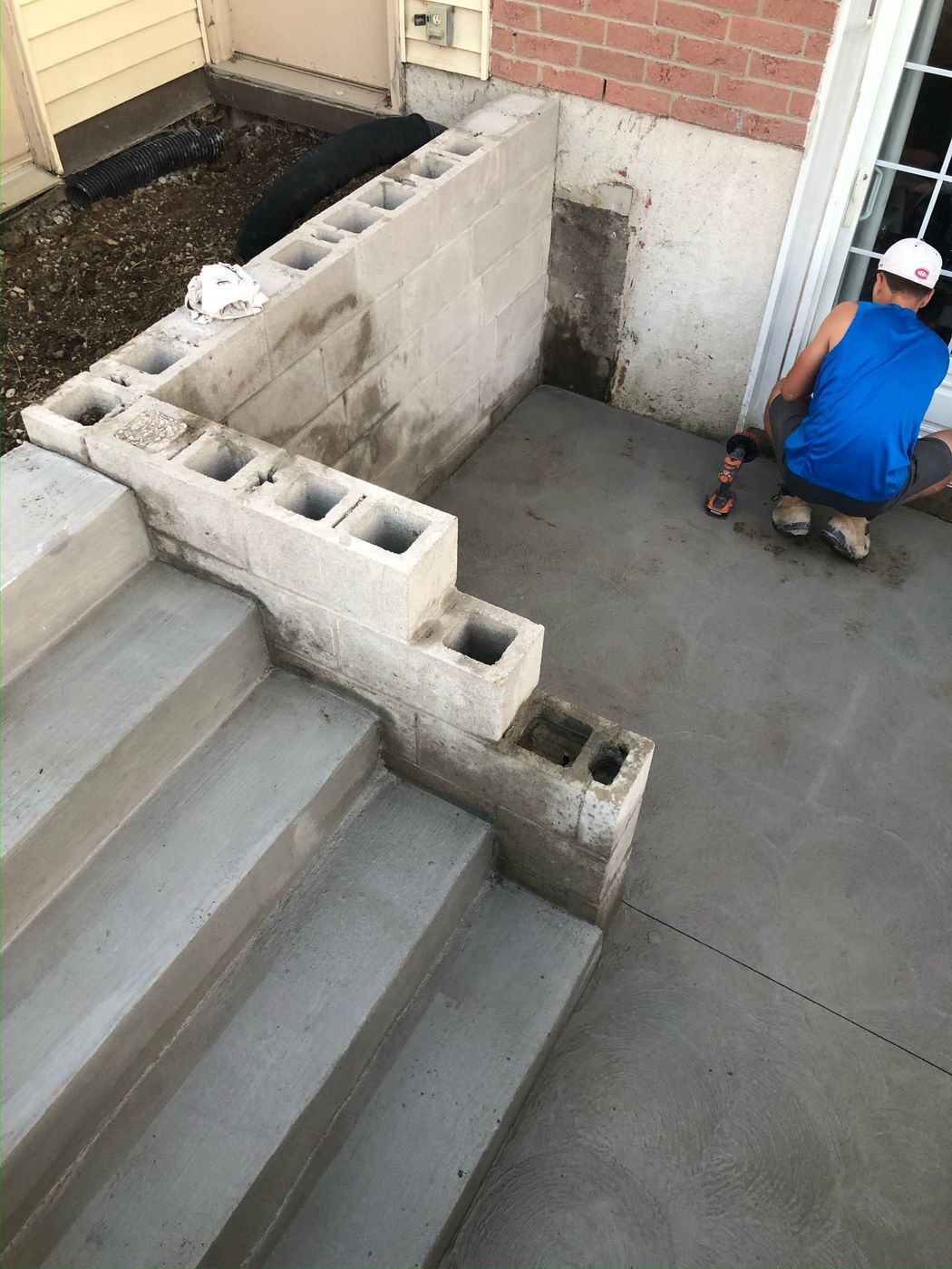 Crew finishing a poured exterior grade entrance with new steps